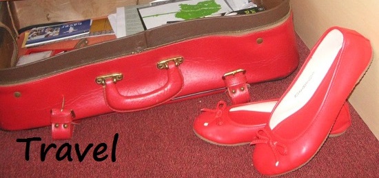 A red suitcase with flat shoes