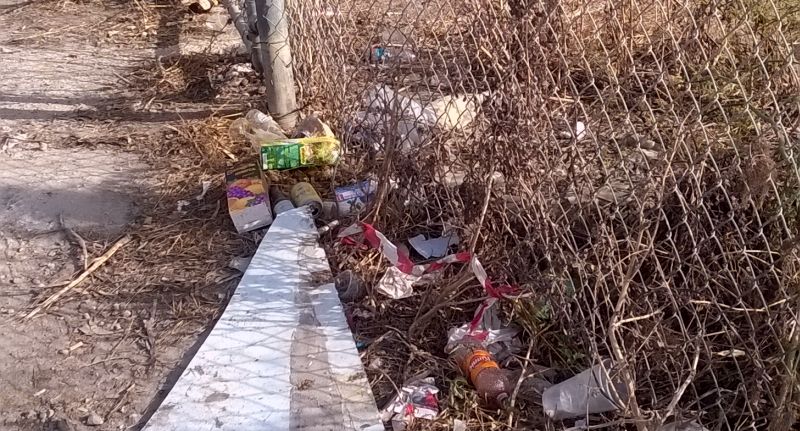 Plastic waste next to a fence