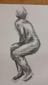 Figure of a woman looking away, drawn in coal