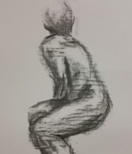 Figure of a woman looking away, drawn in coal